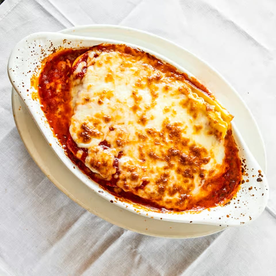 A baked lasagna dish from Sali's Pizza & Pasta, topped with melted, bubbly cheese and rich red sauce.